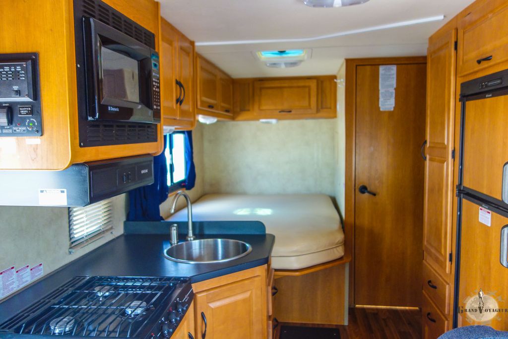 De gauche à droite: gazinière, four micro-ondes, évier, lit, porte de la douche et des toilettes, un placard, et le frigo/freezer. De gauche à droite: gazinière, four micro-ondes, évier, lit, porte de la douche et des toilettes, un placard, et le frigo/freezer.