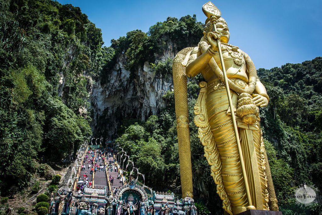 L'entrée du temple est gardée par Kârttikeya (कार्तिकेय en hindi, முருகன் en tamoul), Dieu de la Guerre. Du haut de ses 43 m, c'est la plus grande statue de Kârttikeya au monde. Derrière lui, les marches conduisant vers les grottes. L'entrée du temple est gardée par Kârttikeya (कार्तिकेय en hindi, முருகன் en tamoul), Dieu de la Guerre. Du haut de ses 43 m, c'est la plus grande statue de Kârttikeya au monde. Derrière lui, les marches conduisant vers les grottes.