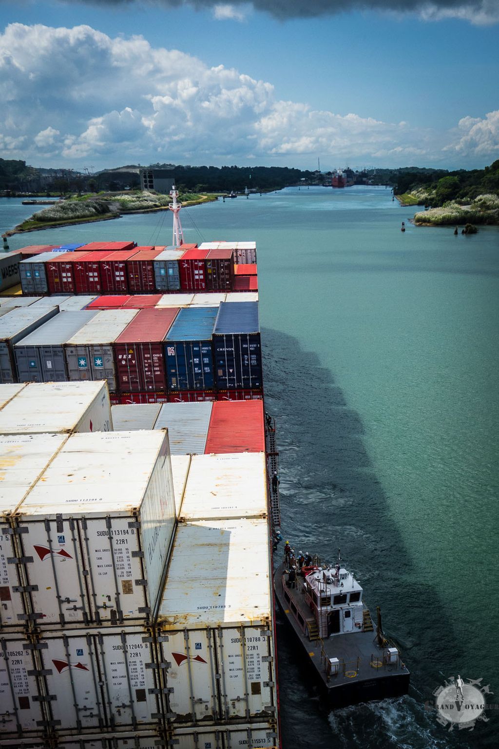 Depuis leur (petit) bateau, l'équipage panaméen et le pilote montent à bord. Au fond, on distingue la première écluse. Depuis leur (petit) bateau, l'équipage panaméen et le pilote montent à bord. Au fond, on distingue la première écluse.